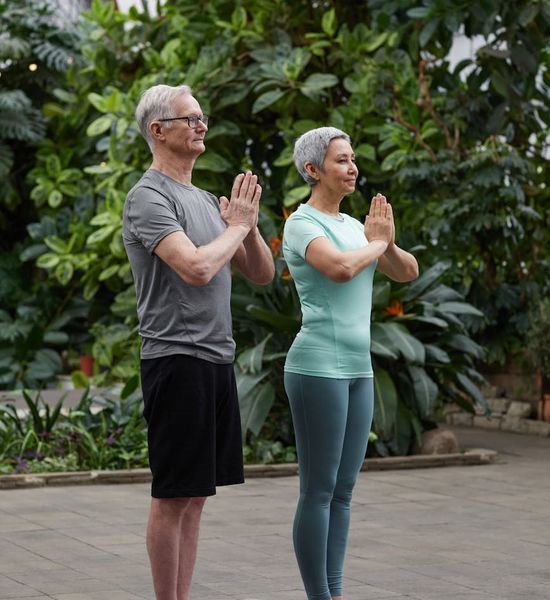 Diverse oameni practicând yoga într-un spațiu luminos și aerisit.